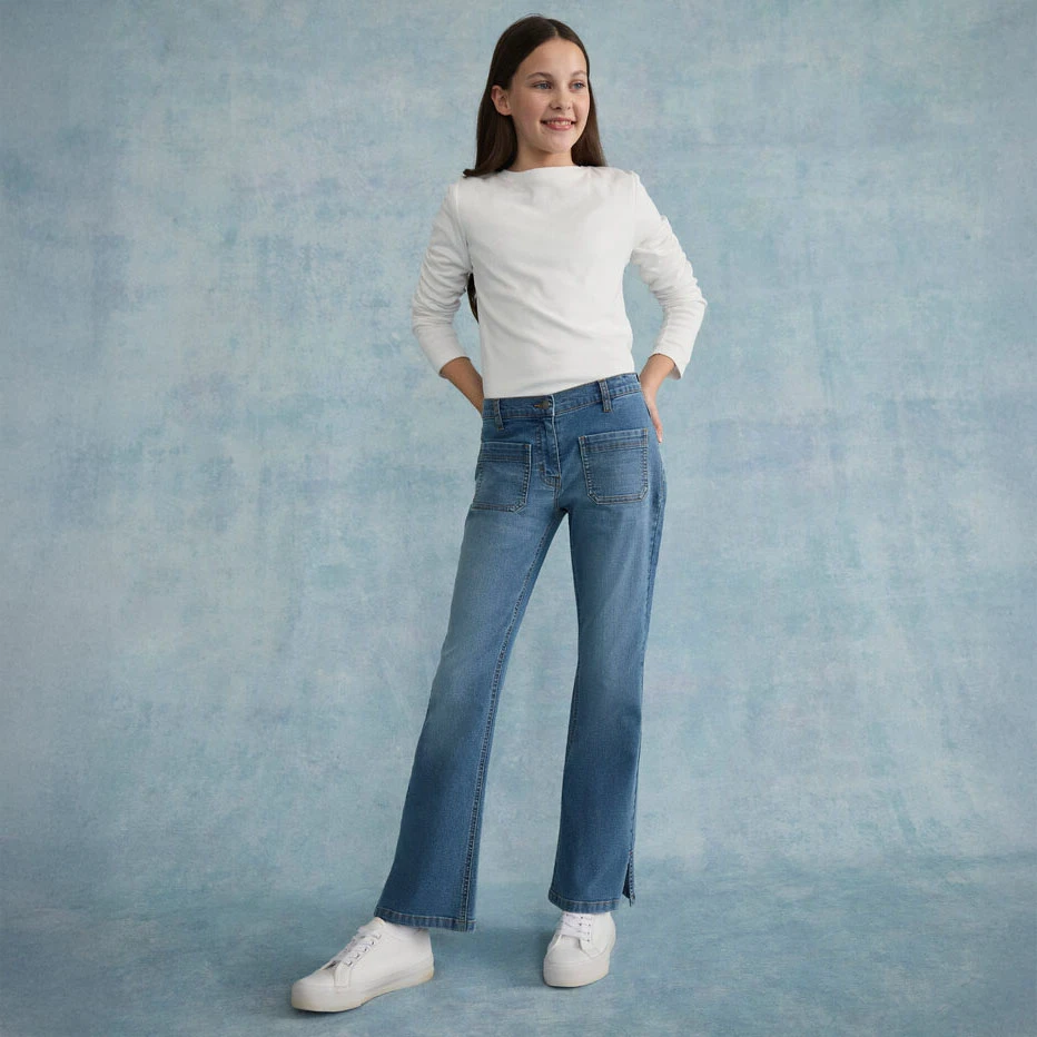 Jednoduchý bílý longsleeve v kombinaci s volnými džínami a bílými teniskami.