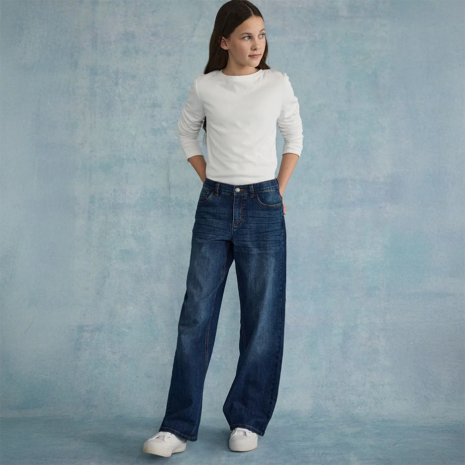 Bílý strukturovaný top zkombinovaný s širokými džínami a bílými teniskami.