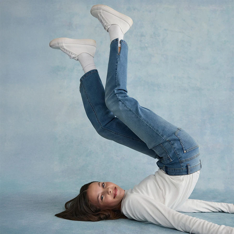 Bílá halenka v kombinaci se skinny džínami a bílými botami.