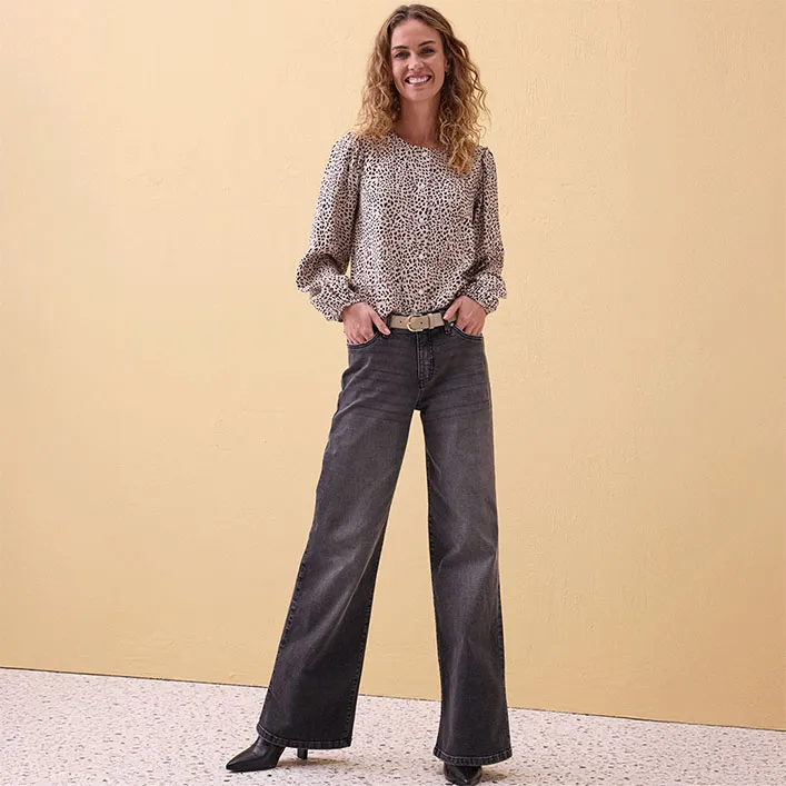 Vzdušná vzorovaná halenka s nafouknutými rukávy v kombinaci s rozšířenými šedými džínami.