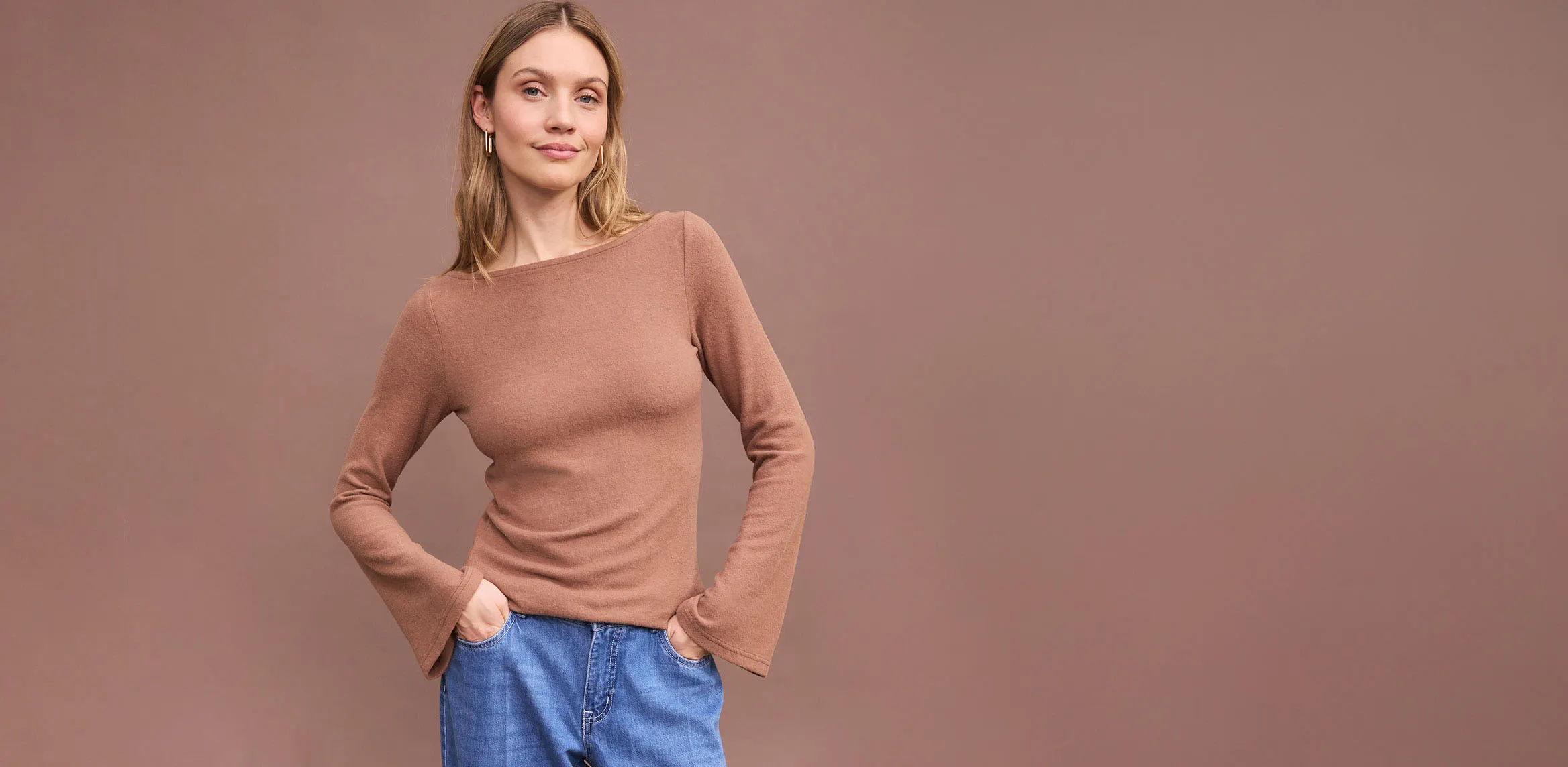 Hnědé triko s dlouhým rukávem a pohodlné modé džíny.