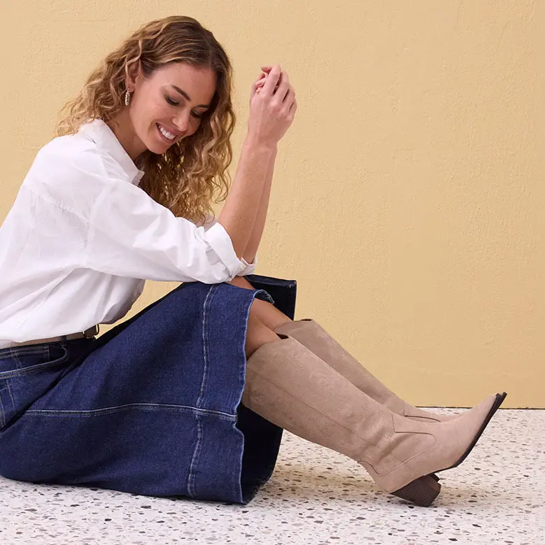 Bílá halenka, široká džínová sukně a béžové kozačky.