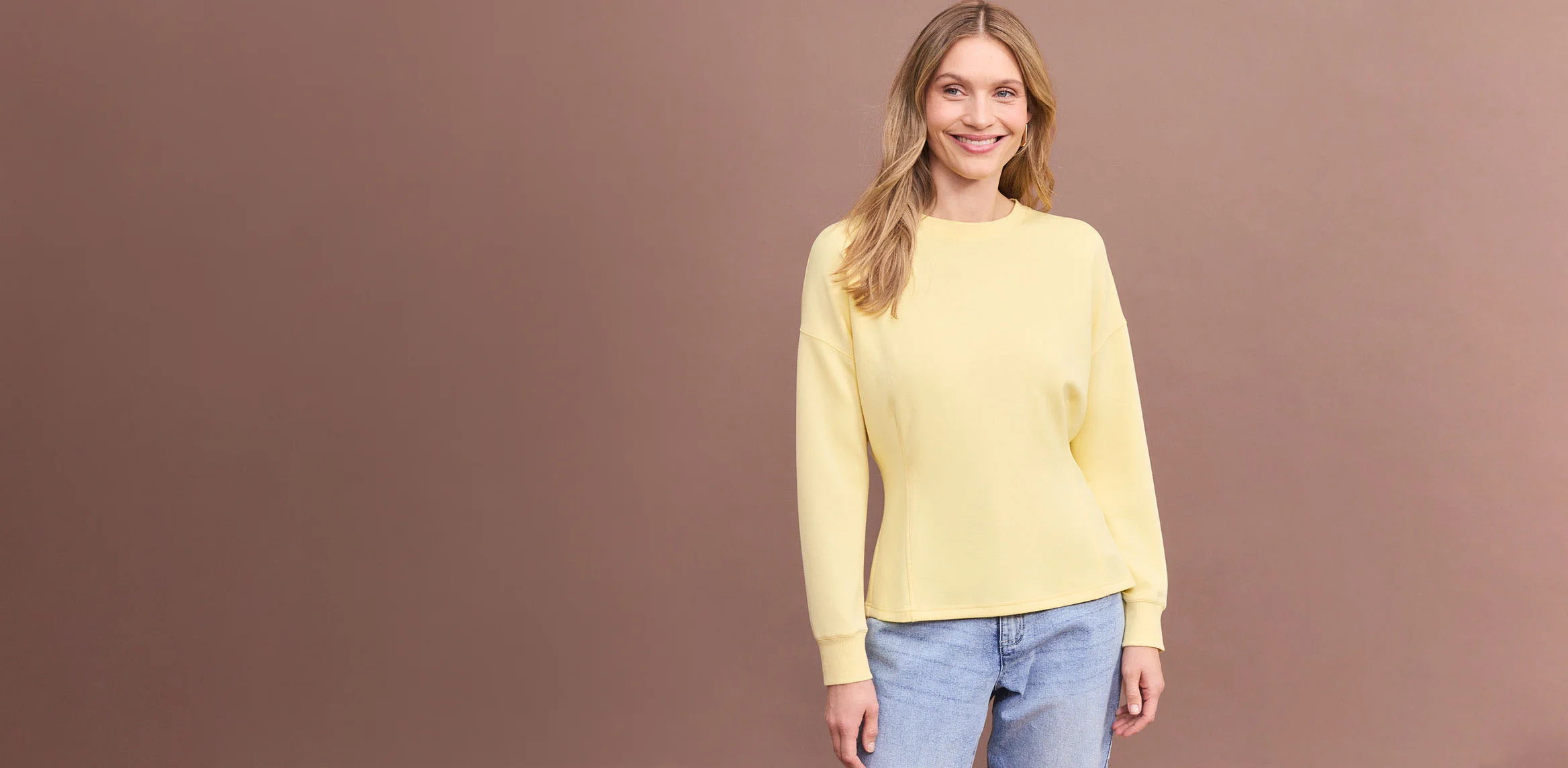 Hnědé triko s dlouhým rukávem a pohodlné modé džíny.