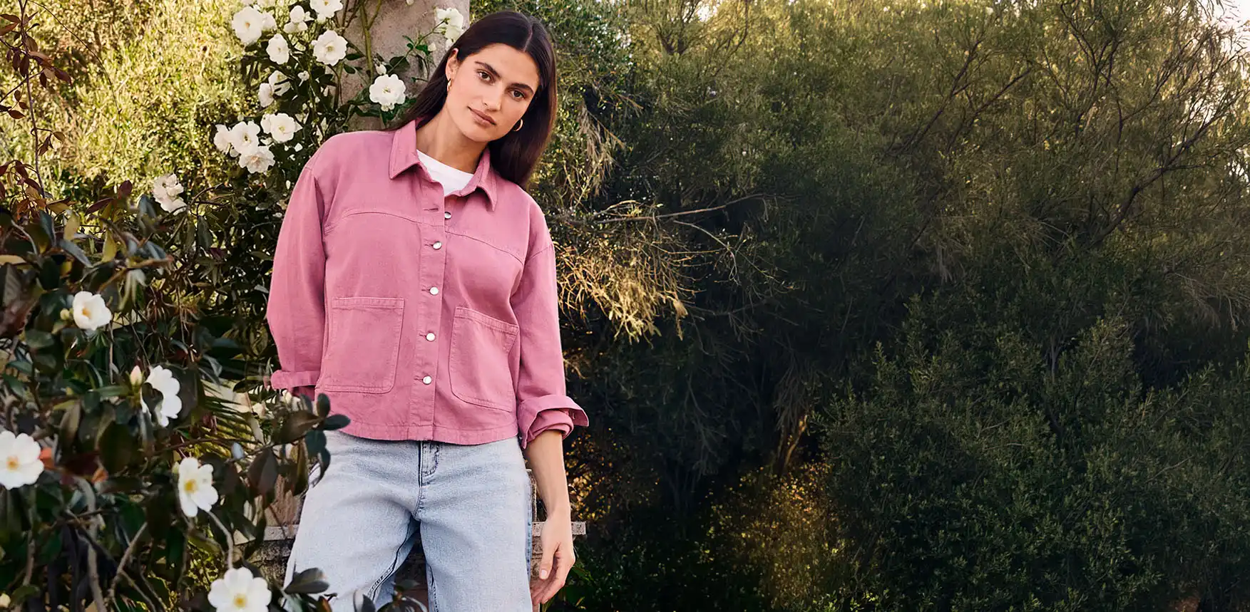 Růžová košile s knoflíky a kapsami, pod ní bílé triko a k tomu světlé džíny vytvoří letní outfit.