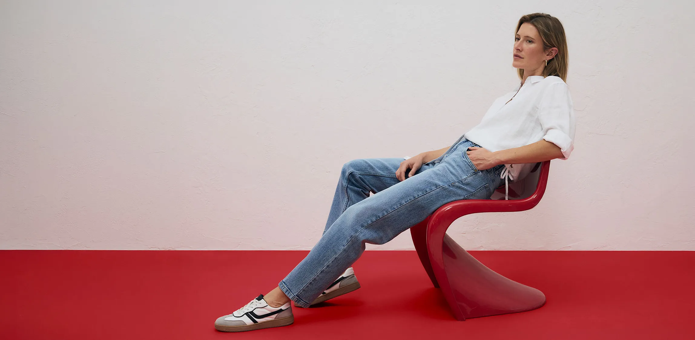 Bílá košile a světle modré džíny, v kombinaci s teniskami.