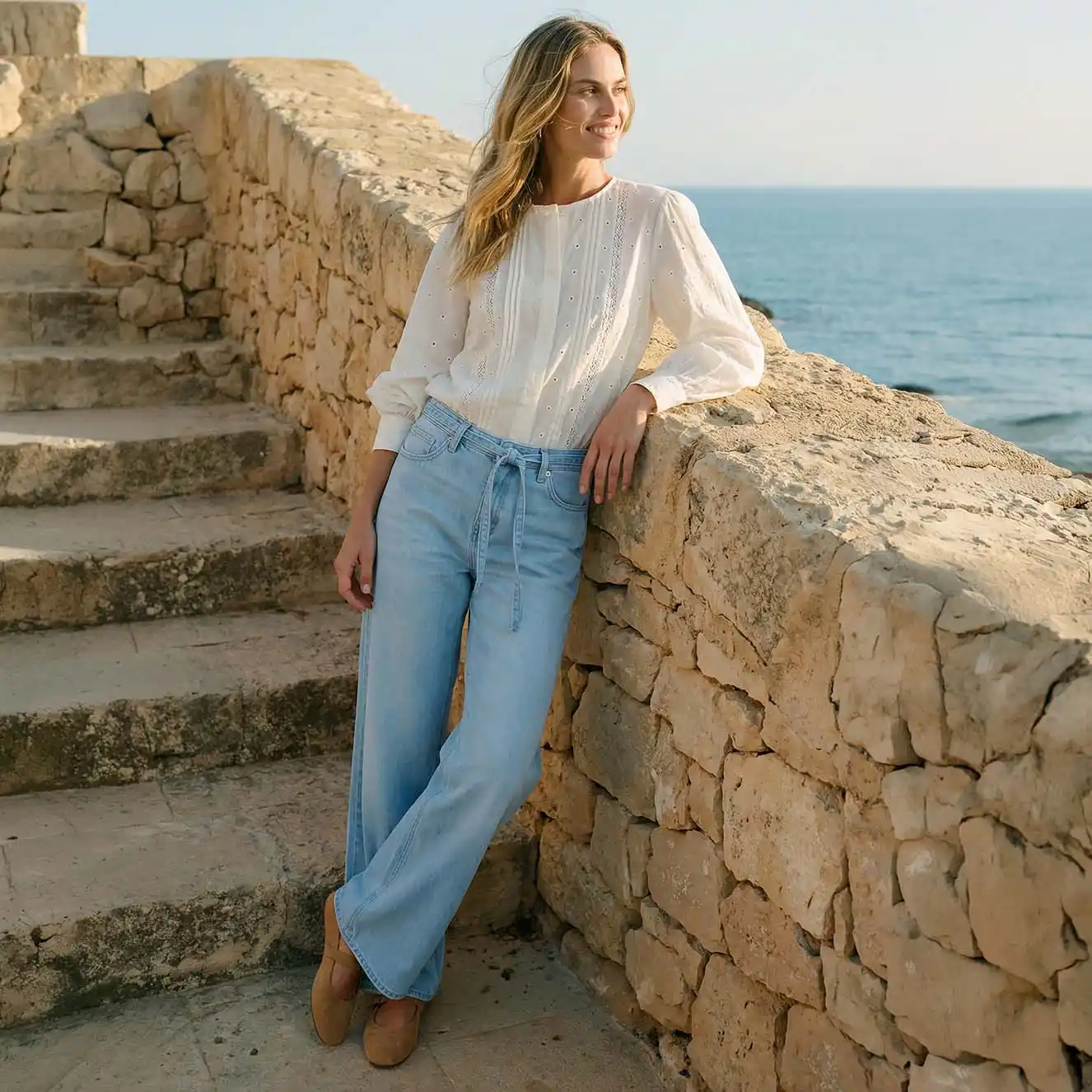 Vzdušná bílá halenka v kombinaci se světle modrými džínami.