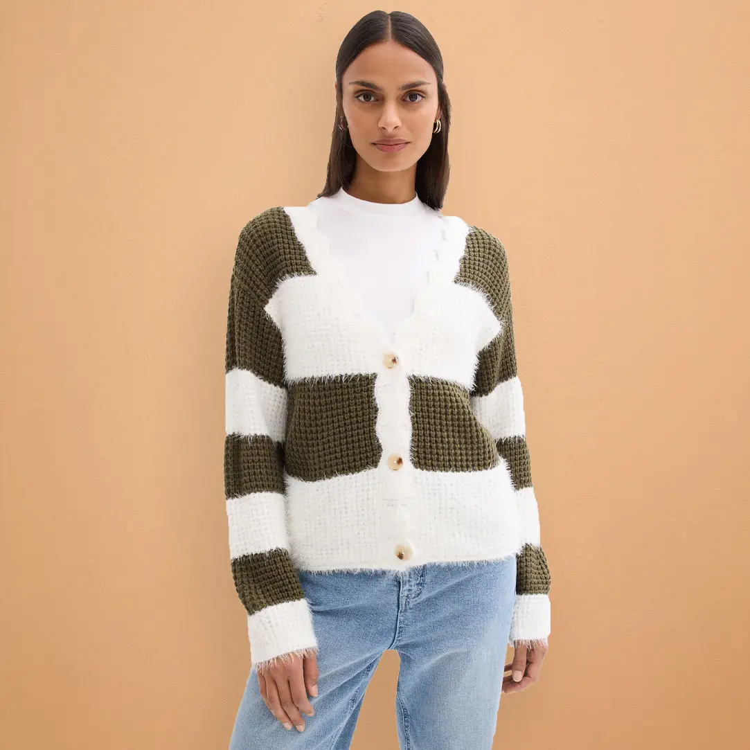 Pletený kardigan v bílé a olivově zelené barvě, v kombinaci se světle modrými džínami.