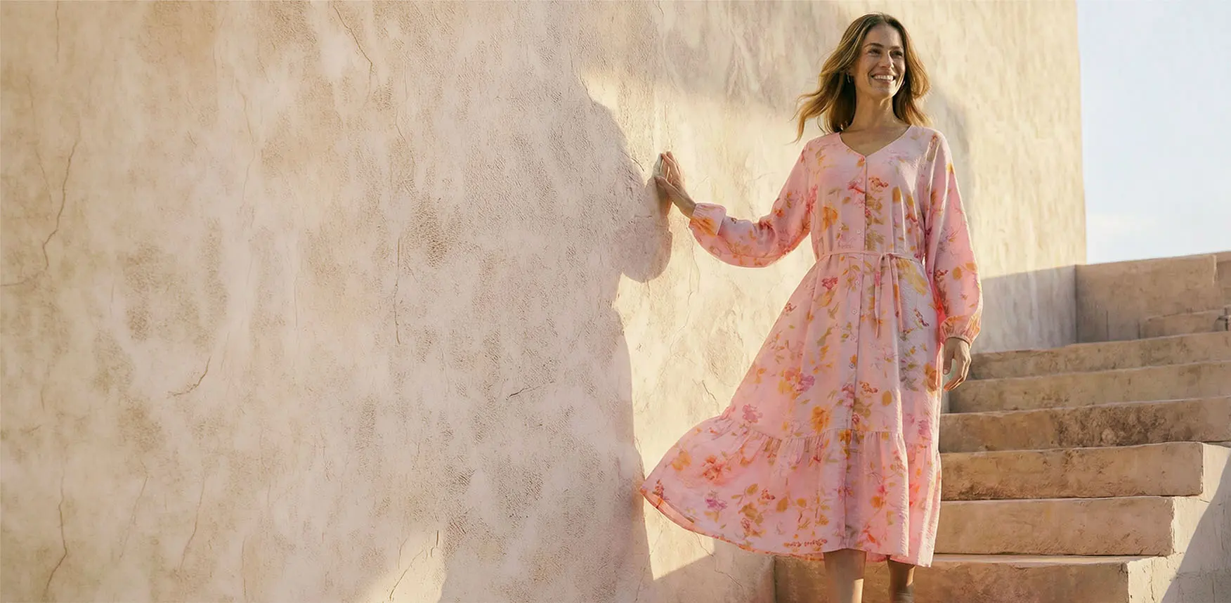 Jemně růžové šaty s květovaným vzorem.