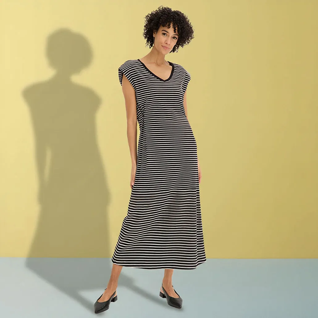 Elegantní černo-bíle pruhované maxi šaty s výstřihem do V a černými balerínami.