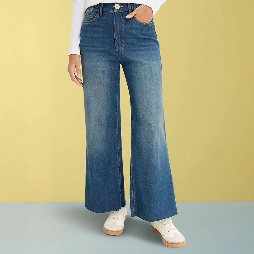 Široké džíny s bílým topem a světlými teniskami.