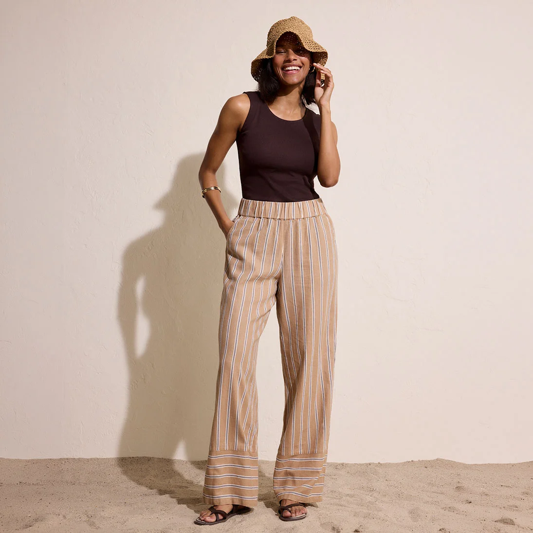 Černý top v kombinaci se vzdušnými, pruhovanými kalhotami v hřejivých zemitých odstínech vytvoří ležérní letní outfit.