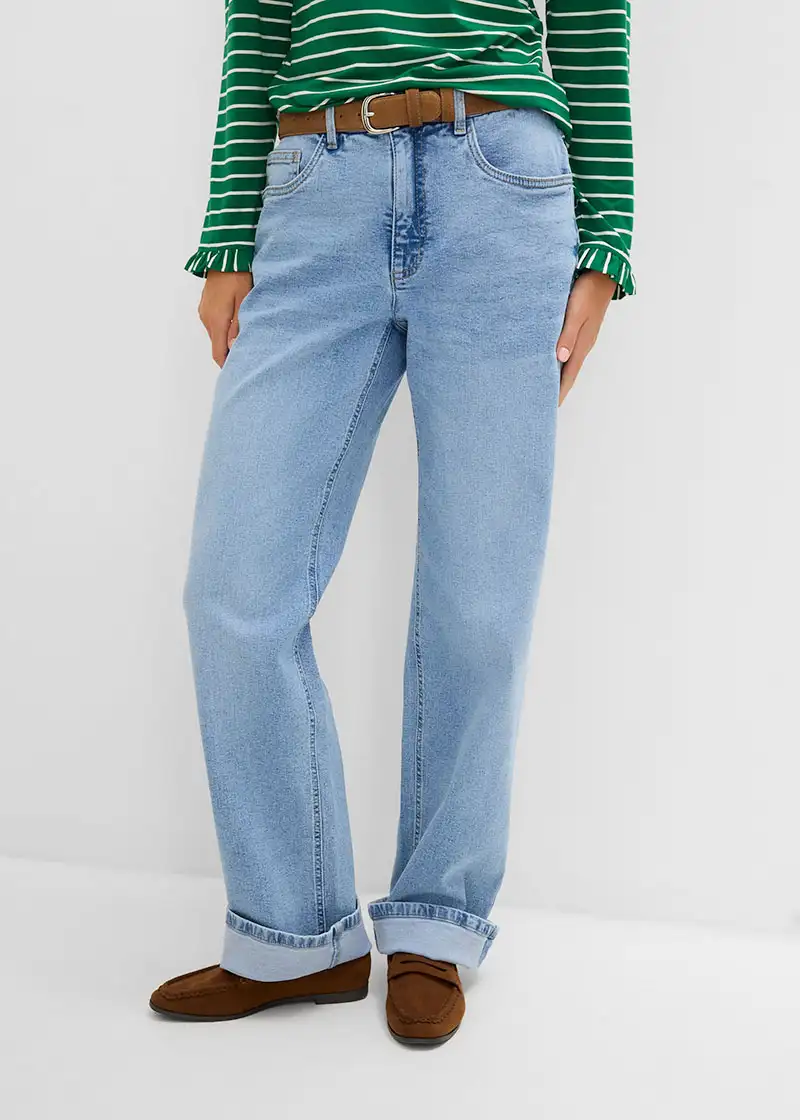 Moderní outfit: pruhované tričko, široké světlemodré džíny, hnědý pásek a hnědé semišové mokasíny.